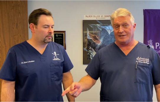 Dr. Prather standing next to another doctor, both in navy scrubs.