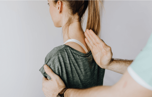 Chiropractor holding a hand on a patient's spine.