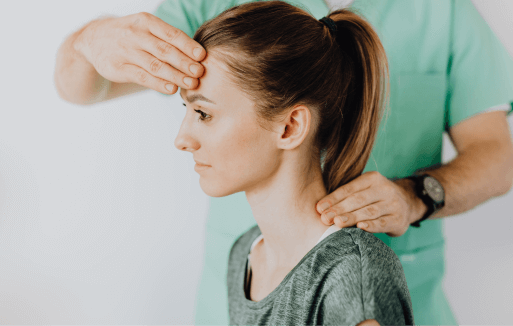 Chiropractor holding the back of a patient's neck and their forehead.
